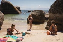 Девушка фотографирует своих братьев и сестер с мобильного телефона на пляже — стоковое фото