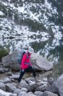 Жінка з рюкзаком ходить на березі озера взимку — стокове фото