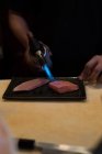 Koch kocht Fischscheiben mit Taschenlampe im Restaurant — Stockfoto