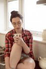 Mujer reflexiva sosteniendo la taza de café en la cocina en casa . - foto de stock