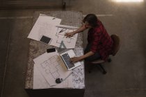 Молодая женщина-инженер с ноутбуком в мастерской . — стоковое фото