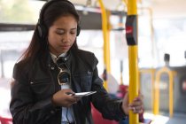 Adolescente utilizando el teléfono móvil en el autobús - foto de stock