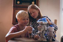 Мать и дочь ремонтируют роботизированную игрушку дома — стоковое фото