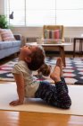 Cute girl performing yoga in living room at home — Stock Photo