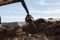 Crane lifting scrap metal in the junkyard — Stock Photo