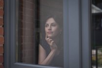 Esecutivo femminile guardando attraverso la finestra in ufficio — Foto stock