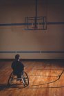 Hombre discapacitado mirando aro de baloncesto en la cancha - foto de stock