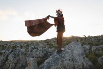 Massai-Mann in traditioneller Kleidung steht mit Schal auf Felsen — Stockfoto