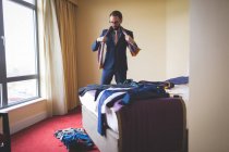 Empresário inteligente vestindo sua gravata no quarto de hotel — Fotografia de Stock