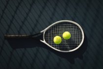 Крупный план теннисного мяча и ракетки на теннисном корте — стоковое фото