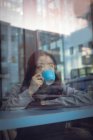 Удумлива жінка, що має каву за столом у кафетерії — стокове фото
