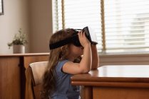 Вид збоку дівчини з використанням гарнітури віртуальної реальності вдома — стокове фото