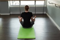 Vue arrière de l'homme pratiquant le yoga dans un studio de fitness . — Photo de stock