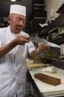 Seniorchef hält Messer in Hotelküche — Stockfoto