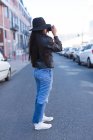 Дівчина-підліток фотографується з камерою на міській вулиці — стокове фото