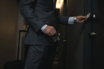 Cropped image of businessman holding access card in hotel — Stock Photo