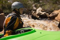 Woman sitting with kayak boat by flowing river. — Stock Photo