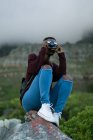 Mulher tirando foto com câmera vintage no campo — Fotografia de Stock