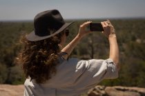 Frau fotografiert mit Handy an einem sonnigen Tag — Stockfoto