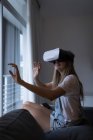 Жінка використовує гарнітуру віртуальної реальності у вітальні вдома . — стокове фото