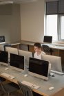 Adolescente estudiando en aula de informática en la universidad - foto de stock
