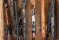 Close-up of various guns arranged in wooden rack — Stock Photo