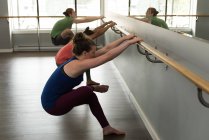 Groupe de personnes en forme pratiquant le yoga avec bar dans un studio de fitness . — Photo de stock