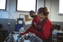 Zwei Arbeiter prüfen Maschinenteile in Fabrik — Stockfoto