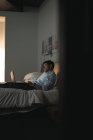 Empresario con portátil en el dormitorio del hotel - foto de stock