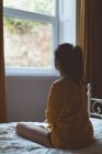 Задумчивая женщина отдыхает в спальне дома — стоковое фото