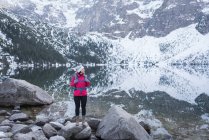 Donna con zaino in piedi sul lungolago durante l'inverno — Foto stock
