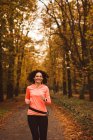 Mujer corriendo en el bosque durante la temporada de autum - foto de stock