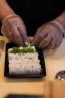 Chef enfeite sushi fatiado no balcão da cozinha — Fotografia de Stock