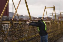 Dock worker adjusting net in shipyard — Stock Photo