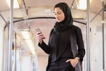 Jovem mulher no hijab usando telefone celular — Fotografia de Stock
