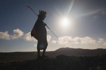 Maasai uomo in piedi con bastone in campagna in una giornata di sole — Foto stock