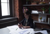 Женщина-руководитель с помощью мобильного телефона в офисе — стоковое фото