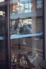 Красива жінка розмовляє по мобільному телефону, маючи каву в кафетерії — стокове фото
