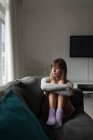 Продуманий жінка розслаблюючим у вітальні на дому — стокове фото