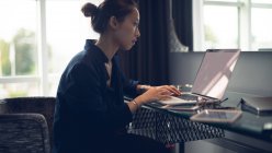 Жінка використовує ноутбук за столом у готельному номері — стокове фото