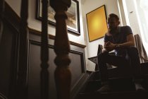 Depressiver Mann sitzt zu Hause auf Treppe — Stockfoto