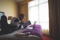 Empresário lendo um livro no quarto de hotel — Fotografia de Stock