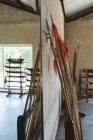 Lange Stangen und Kung-Fu-Speere lehnen an Wand im Kampfsportstudio. — Stockfoto