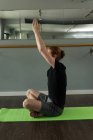 Чоловік практикує йогу на тренувальному килимку у фітнес-студії . — стокове фото