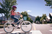 Дівчина їде на велосипеді на зебра перетинаючи місто . — стокове фото