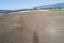 Aeronave de trator arar o campo em um dia ensolarado — Fotografia de Stock