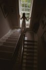 Rear view of bride standing at the window at home — Stock Photo