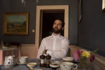 Удумливий наречений сидить перед їжею на столі вдома — стокове фото