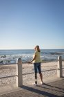 Behinderte Frau steht an Geländer am Strand. — Stockfoto