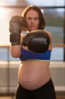 Pregnant woman practicing boxing in living room at home — Stock Photo